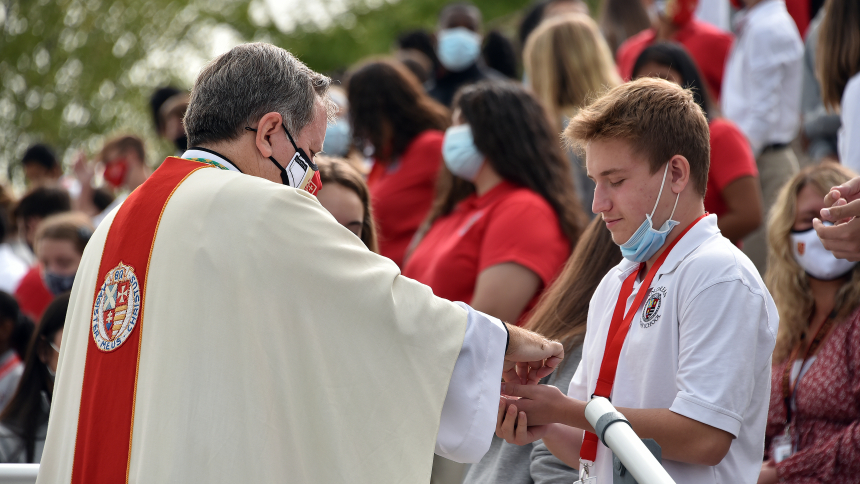 Bishop McClory distributes the Eucharist at an all-school Mass at Andrean Sept. 14, 2020