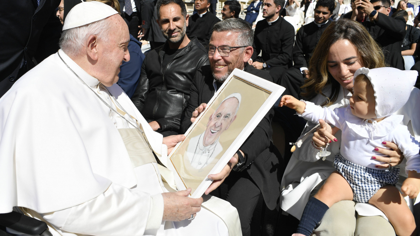 Pope Francis holds a portrait of himself while greeting visitors after his weekly general audience April 26, 2023, in St. Peter's Square at the Vatican. (CNS photo/Vatican Media)