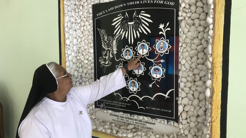 In this photo taken in March 2023, Dominican Sister Sirima Opanayake, principal of Ave Maria Branch School in Sri Lanka, shows pictures of seven students killed in a 2019 Easter bombing at St. Sebastian's Church in Katuwapitiya. (OSV News photo/Thomas Scaria)