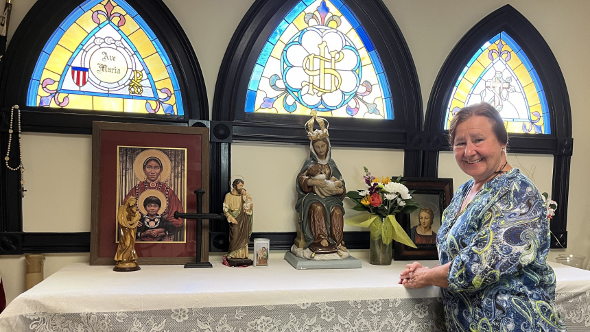 Dr. Mary Soha poses April 24, 2023, next to a statue of Our Lady of La Leche in the chapel in her home adjacent to the Sacred Acre, site of the National Shrine of Our Lady of La Leche at Mission Nombre De Dios in St. Augustine, Fla.