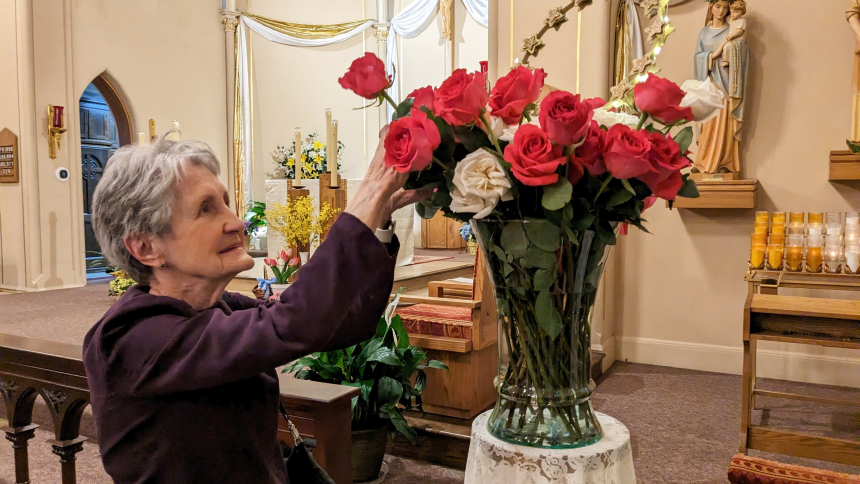 Following Mass, Lillian Smith places a flower in a vase before the Blessed Virgin Mary May 10, at St. Joseph, Dyer. She was one of about 50 women who participated in a closing ceremony of Halo Ladies, the parish's new women's ministry.  (Lynda J. Hemmerling photo)