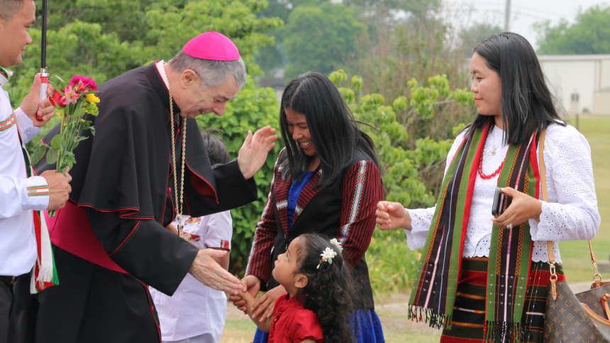 Bishop William F. Medley of Owensboro, Ky., greets a small child in a receiving line of Burmese parishioners outside Holy Spirit Church in Bowling Green June 18, 2023. The Myanmar community was celebrating 14 years of being part of the parish. (OSV News photo/Elizabeth Wong Barnstead, The Western Kentucky Catholic)