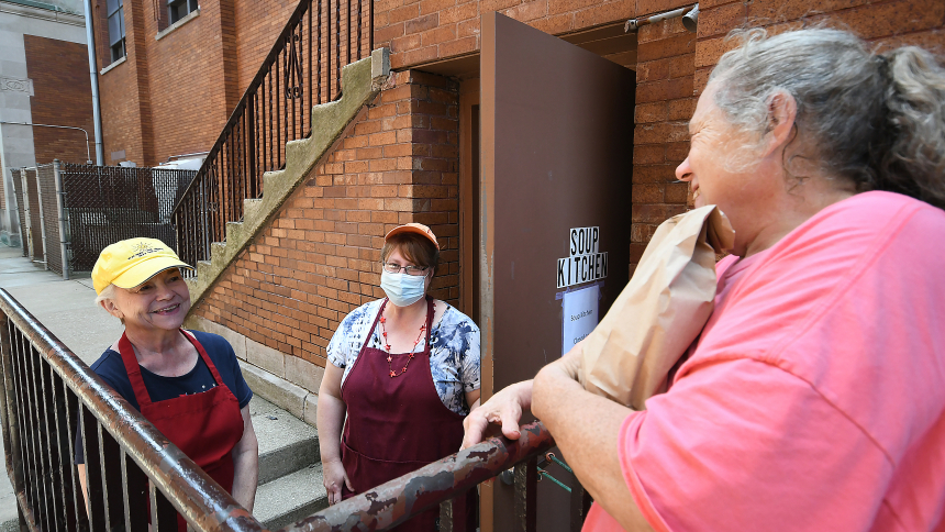 St. Joseph Soup Kitchen volunteers Mary Jo Mazur (left), of Hammond, and Marge Kovacik (center), of Schererville, greet a visitor at the door of the church in Hammond on July 3. The food-for-the-needy initiative was launched in 1985 and now, due to public health concerns, offers to-go lunches. (Anthony D. Alonzo photo)