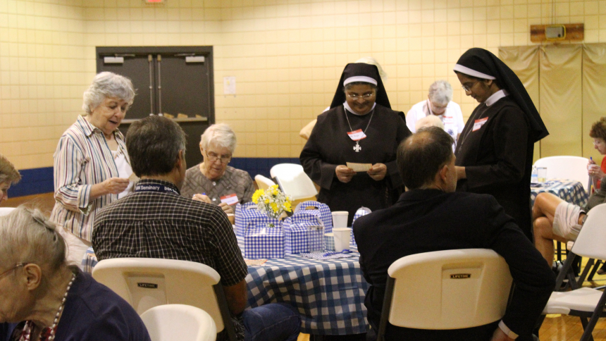 Everyone checks the numbers on their bingo card to see if they are still in the game during the Religious Sisters Picnic hosted by the Serra Club of NWI on June 30 at St. Bridget in Hobart. Club members were joined by more than a dozen nuns who serve in the Diocese of Gary, as well as several seminarians and theur families. (Marlene A. Zloza photo)
