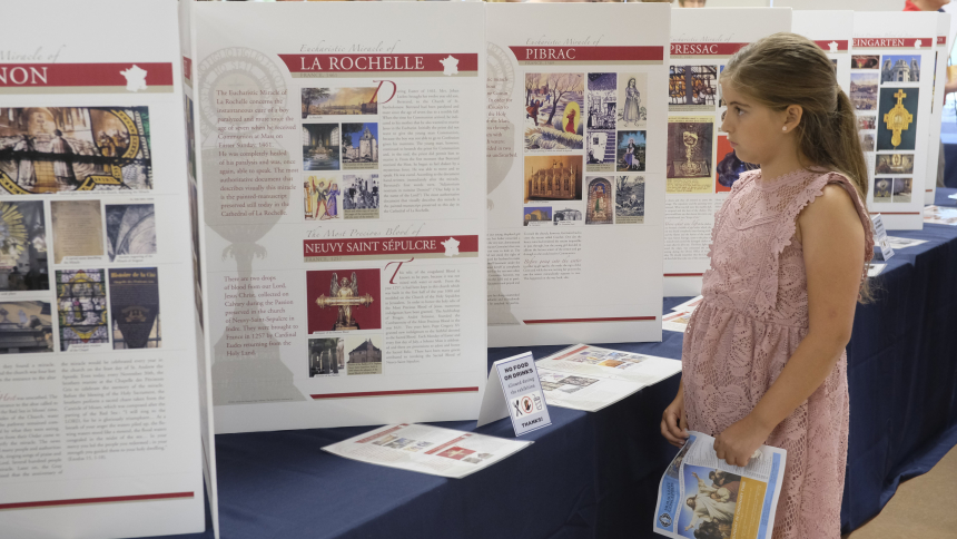 At Immaculate Conception Church in Clarksville, Tenn., Victoria Sanchez, 9, looks over an exhibition created and designed by Blessed Carlo Acutis that explains every Eucharistic miracle documented around the world. The 156-poster display is currently being shown on five different continents and has miracles listed across 20 countries and witnessed by multiple saints and beatified individuals. (OSV News photo/Katie Peterson, Tennessee Register)