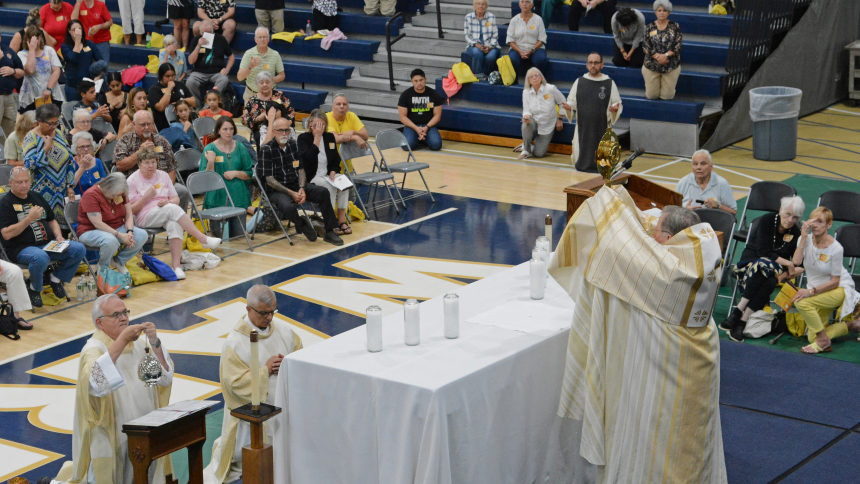 Bishop Robert J. McClory (front, right) raises the monstrance during Exposition of the Blessed Sacrament at Bishop Noll Institute on August 26. About 1,000 area faithful joined the diocesan gathering where Bishop McClory celebrated Mass before an estimated gathering of 1,000 in Hammond, and, later, nationally-known guest speakers presented Catholic perspectives on faith matters. (Anthony D. Alonzo photo)