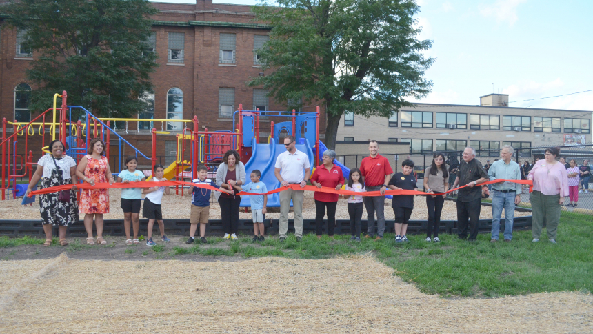 Angelica Foy, principal of St. Stanislaus School in East Chicago, with the help of staff, students and donors, cuts a ribbon on Aug. 11 signifying the opening of a new playground on the school grounds. (Erin Ciszczon photo)