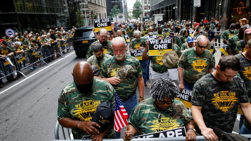 Members of United Mine Workers of America and other labor leaders bow in prayer while picketing July 28, 2021, outside BlackRock's headquarters in New York City as part of the union's strike at Warrior Met Coal Mine. (OSV News photo/Brendan McDermid, Reuters)