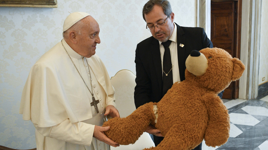 Pope Francis receives a stuffed bear, a symbol of Ukraine's suffering, from Andrii Yurash, Ukrainian ambassador to the Holy See, during a meeting in the library of the Apostolic Palace at the Vatican Sept. 22, 2023. The bear survived a Russian missile strike in Dnipro, Ukraine, that killed 46 people, including three children, and wounded 75 others. (CNS photo/Vatican Media)