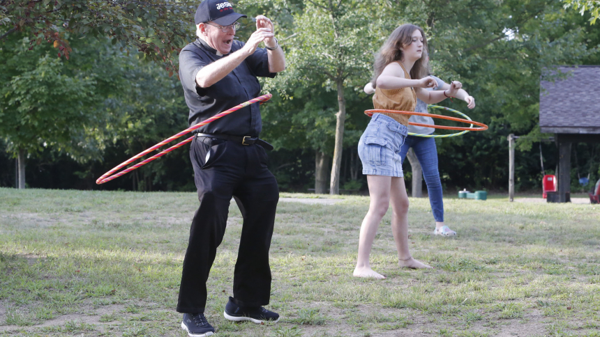Father Terry Bennis and 14-year-old Brielle Brunicon attempt to hula hoop during the Ss. Cyril and Methodius and All Saints parish picnic on Aug. 19 in North Judson. Bishop Robert J. McClory celebrated Mass in the park and visited with the faithful during the picnic. (Bob Wellinski photo)