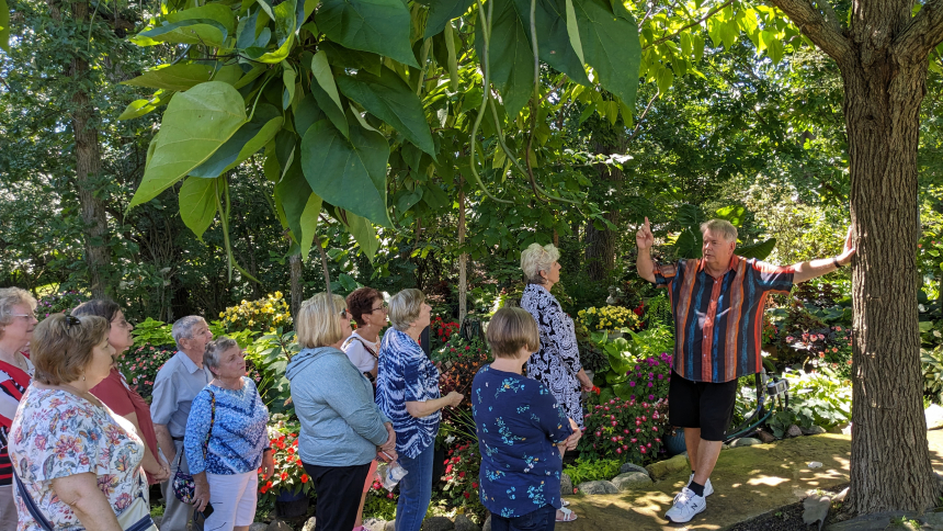 Father Sammie Maletta gives about 50 members of the St. John the Evangelist Boomers and Beyond group a tour of his garden on Aug. 31. He has developed a passion for gardening and cooking and loves to share his talents and hobbies with others. (Lynda J. Hemmerling photo)