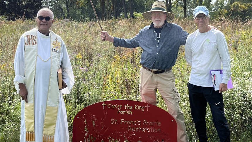 Caption: Father Carlos Saligumba, pastor of Christ the King Church in Wonder Lake, Ill., poses with John Shiel and Dave Zeiger at a sign for the St. Francis prairie restoration project, which was 22 years in the making. About 20 people gathered Sept. 24, 2023, for the dedication of the project to St. Francis of Assisi, patron saint of ecology and animals. (OSV News photo/Megan Peterson for The Observer)