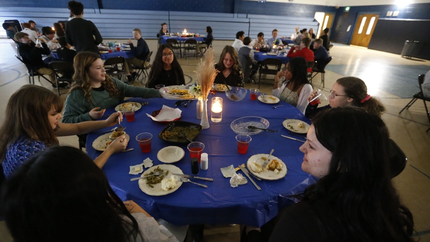 Queen of All Saints seventh and eighth graders enjoy a turkey dinner by candlelight on Nov. 16. The dinner in a formal setting allowed the students to learn and practice manners and etiquette. (Bob Wellinski photo)