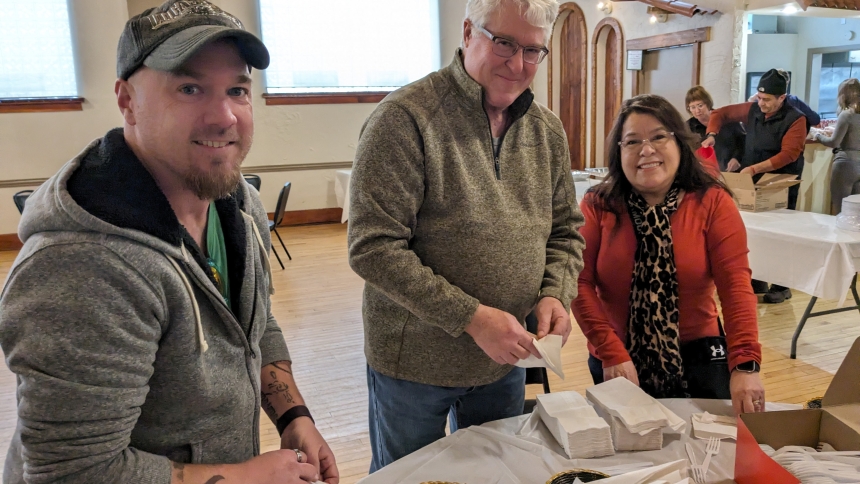 St. John the Evangelist parishioners T.J. Nee and Matt Rohr accompany Rosa Marian, of St. Patrick, in putting together plasticware settings. The three participated with about 30 other volunteers who prepared food and served about 30 people at the St. Patrick Soup Kitchen on Jan. 6. (Lynda J. Hemmerling photo)