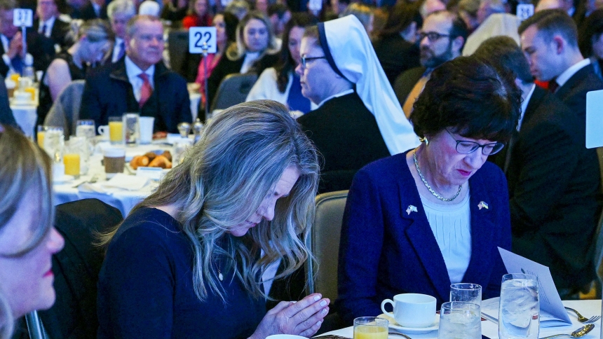 An unidentified women, center, prays next to Sen. Susan Collins, R-Maine, right, during the National Catholic Prayer Breakfast in Washington Feb. 8, 2024. (OSV News photo/Leslie E. Kossoff)