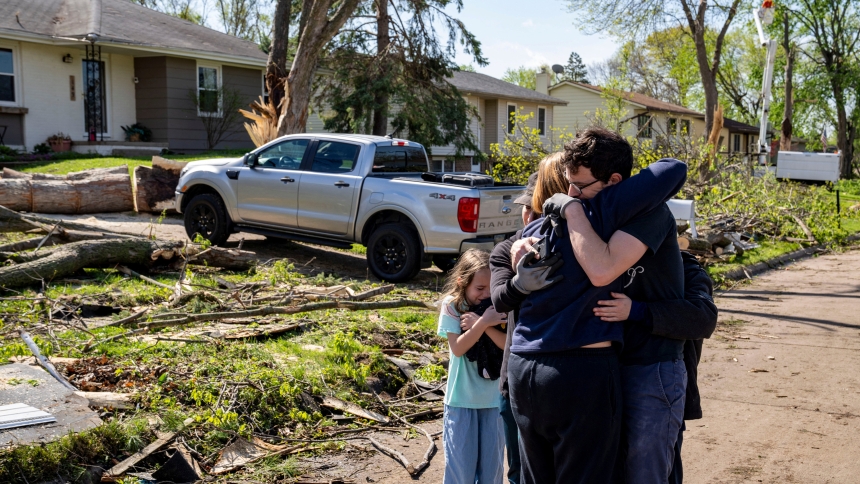Neighbors embrace Penny Thomsen outside of her home in Des Moines, Iowa, April 27, 2024, following a tornado the previous day. A tornado plowed through suburban Omaha, Neb., demolishing homes and businesses as it moved for miles through farmland and into subdivisions, then slamming Des Moines. (OSV News Zach Boyden-Holmes, The Register/USA Today Network via Reuters)