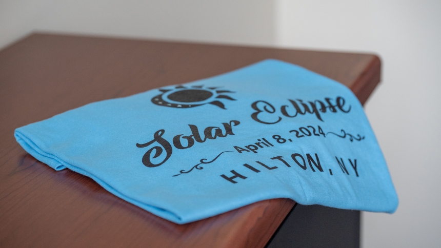 Members of the Knights of Columbus at St. Leo Parish in Hilton, N.Y., have been selling these commemorative T-shirts leading up to the total solar eclipse April 8, 2024. More than half of the Rochester Diocese is situated in the eclipse's 115-mile-wide "path of totality." That's where the the moon will completely block the face of the sun, resulting in a short period of rare daytime darkness. (OSV News photo/Jeff Witherow, Catholic Courier)