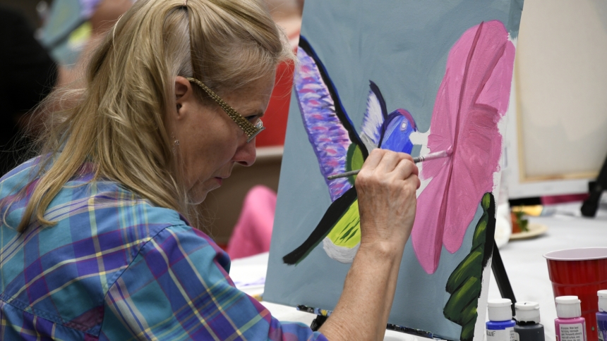 Joanne Besich concentrates on her brush strokes as she paints a hummingbird on April 17 in Sacred Heart Hall at Holy Name of Jesus church in Cedar Lake. Part of the “Crafting with a Purpose” series, parish volunteers were happy to see more than 50 church members and guests attend the class featuring guidance for hands-on art projects. (Anthony D. Alonzo photo)