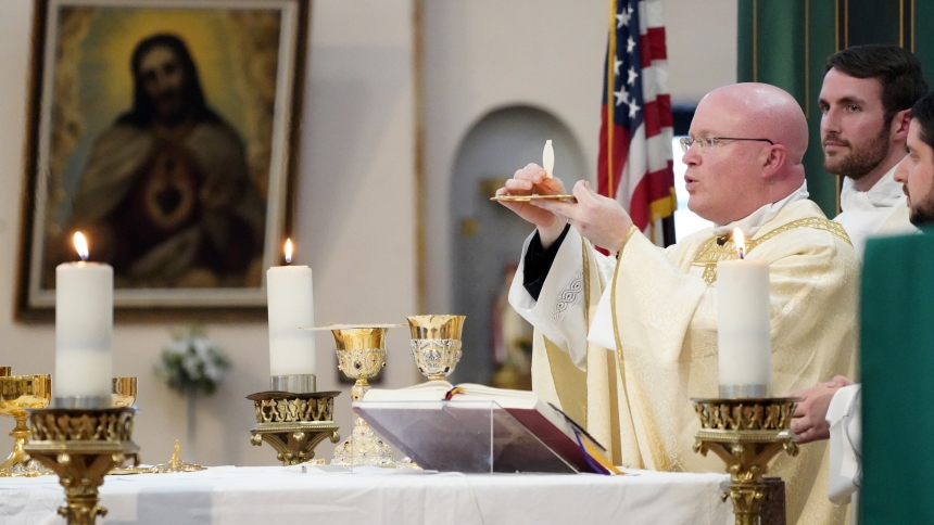 Father Roger Landry, chaplain at Columbia University, elevates the Eucharist during Mass at Sacred Heart of Jesus Church in New York City Oct. 11, 2022. Father Landry may be the reason 24 young people and several priests are walking thousands of miles across the U.S. this summer during the National Eucharistic Pilgrimage. (OSV News photo/Gregory A. Shemitz)