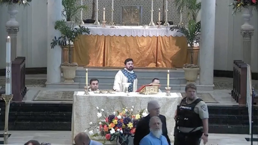 Father Nicholas G. DuPre (center), associate pastor at St. Mary Magdalen Parish in Abbeville, Louisiana, leads parishioners in prayer as a teenager attempted to enter the church with a rifle during a first Communion Mass May 11, 2024. (OSV News photo/St. Mary Magdalen live stream screenshot)