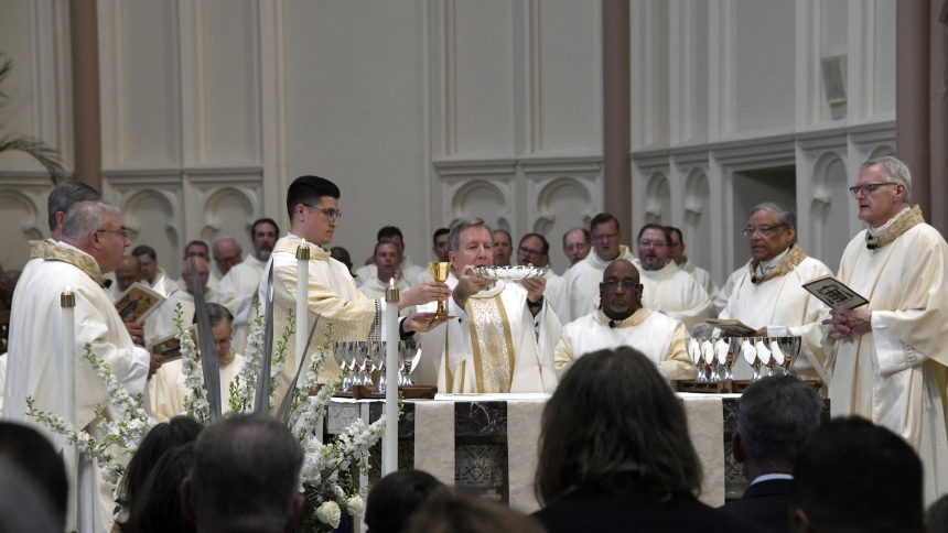Bishop Robert J. McClory (center) raises a communion plate as transitional Deacon Zachary Glick raises the chalice during the Eucharistic prayer at Mass in the Cathedral of the Holy Angels where the fifth Bishop of Gary joined invited family and friends and diocesan faithful to mark his 25th anniversary of priestly ordination, on May 10. Growing up in Royal Oak, Mich., Bishop McClory was ordained to the priesthood for the Archdiocese of Detroit in 1999, after seminary studies, which followed his brief caree