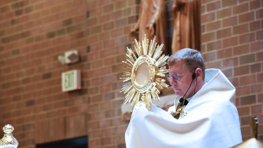 St. Mary pastor Father Kevin Huber raises the monstrance as he leads benediction in June 2023. Father Huber and the congregation of the Crown Point parish will host "True Presence: A Night of Praise, Worship and Adoration" on Friday, May 31, as part of the Summer of Eucharistic Revival events within the Diocese of Gary. (Anthony D. Alonzo photo)