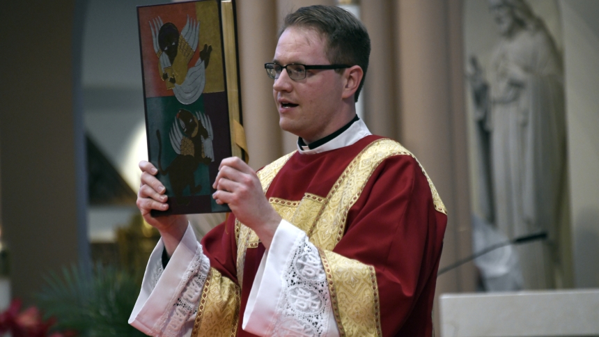 Transitional deacon Steven Caraher carries the Book of Gospels during Mass at the Cathedral of the Holy Angels in Gary on May 19. Caraher, a native of Munster and St. Thomas More parish, completed seminary studies at Sacred Heart Major Seminary in Detoit and awaits ordination to the priesthood, set for June 1 at the cathedral. (Anthony D. Alonzo photo) 
