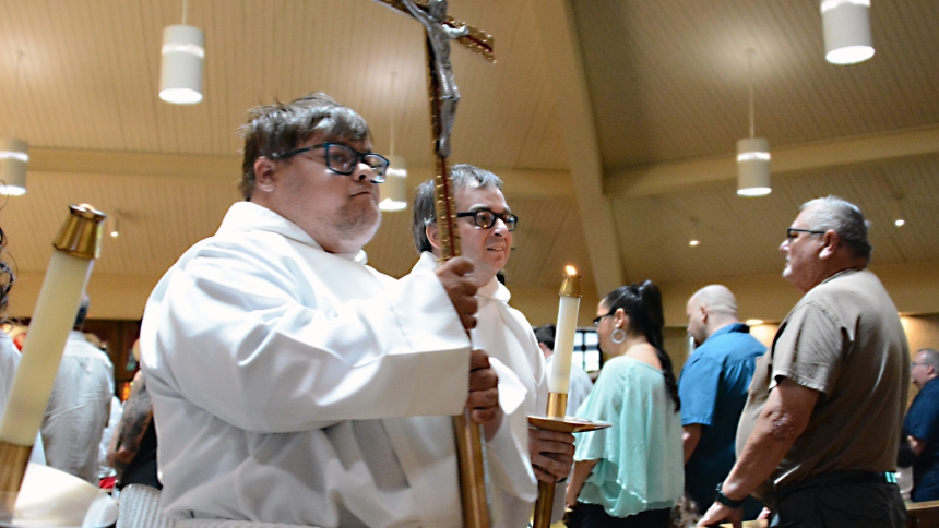 Altar servers Zach Campbell (front, left) and Chris Neff carry the processional cross and candles during the Mass of Inclusion at St. Thomas More in Munster on June 23. AIM was publicly launched in March 2023 with a focus on engaging those with special needs with the worship and fellowship of the Church. (Anthony D. Alonzo photo)