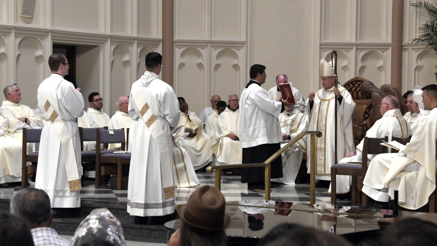 At the Cathedral of the Holy Angels, Bishop Robert J. McClory (right) speaks to transitional deacons Steven Caraher (middle, left) and Zachary Glick (middle, right) during the presentation of the candidates at the Mass of Ordination among the presence of dozens of diocesan clergymen and a full house of faithful in Gary on June 1. Father Caraher, a Munster native and St. Thomas More School alumnus, and Father Glick, a Highland native and Our Lady of Grace School alumnus, began their priestly service in the d