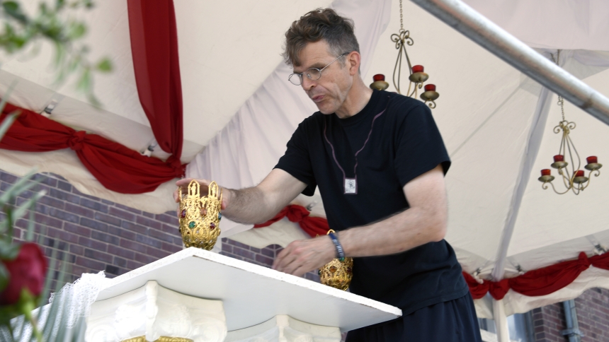 Archdiocese of Indianapolis priest Father Jonathan Meyer, a member of the USCCB’s Eucharistic Procession sub-committee, decorates the altar upon which the processional monstrance will be set, in a float parked at Holy Rosary church on July 20.  With the help of archdiocesan volunteers, Father Meyer and the crew completed the project that morning for the grand Eucharistic procession where thousands of Catholics walked in downtown Indianapolis to the Indiana World War Memorial Plaza for a benediction and prai
