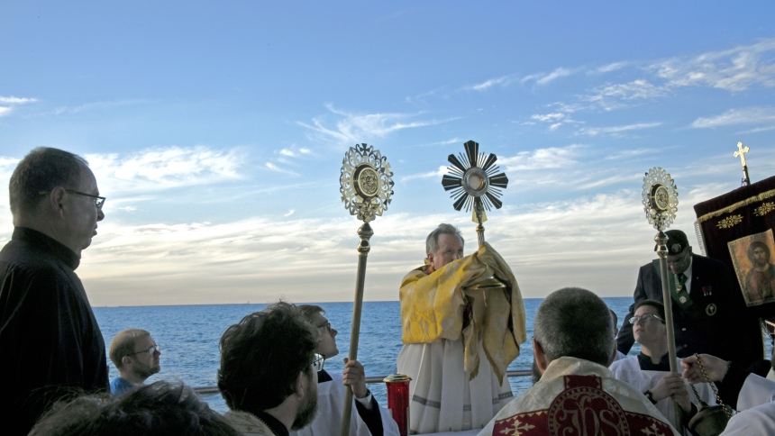 Bishop Robert J. McClory elevates the monstrance during benediction at Lakefront Park in Whiting as worshippers kneel before the Blessed Sacrament along with members of the perpetual pilgrims contingent traveling on the Marian Route of the National Eucharistic pilgrimage on July 1. Hundreds of diocesan faithful and visitors took part in the day's Christ-centered prayer, presentations, procession, benediction and festivities, which began at St. Mary Byzantine Catholic church and concluded at the Lake Michiga