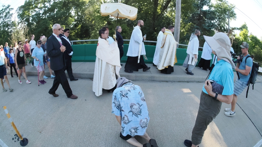 Richard Stith, a St. Paul Catholic Church parishioner, kneels as the Deacon Ivan Alatorre carries the Blessed Sacrament along Campbell St. enroute to St. Paul Catholic Church as part the National Eucharistic Pilgrimage on July 3 in Valparaiso. Hundreds joined in the Eucharistic procession that began at St. Teresa of Avila Student Center. Richard’s wife, Rosemarie is standing next to him. (Deacon Bob Wellinski photo)