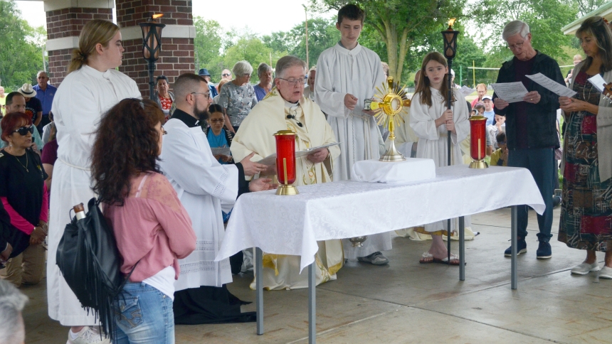 Father Martin J. Dobrzynski, pastor of St. Michael the Archangel in Schererville, prays with faithful in front of the Blessed Sacrament on July 2 in Redar Memorial Park in Schererville, Ind. Following adoration, pilgrims processed along the Old Savannah Trail, traveling 20 miles to Nativity of Our Savior in Portage, Ind. (Erin Ciszczon photo)