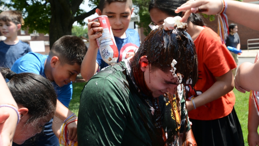 Totus Tuus missionary Mac Nowalk (center) finds himself covered with various edible toppings, as students from the summer religious education classes continue to pour it on at St. Mary parish in East Chicago on June 21. Since 2016, Sean Martin, of the Diocese of Gary's Office of Office of Missionary Discipleship and Evangelization (Catechesis and Faith Formation), has coordinated the program that offers Totus Tuus sessions at multiple parish locations. (Anthony D. Alonzo photo) 