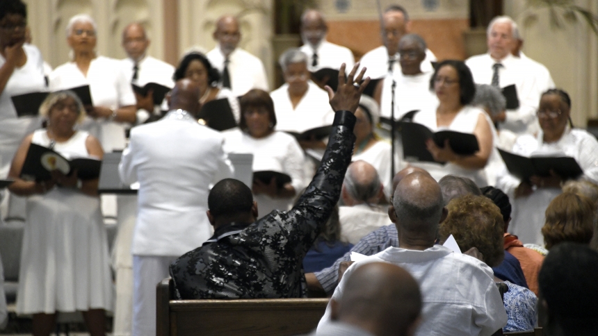 Church elder Antonio Sparks from Faith United in Dolton, Ill. raises his hand in praise as choir members perform during the Community Hymn & Spiritual Fest at the Cathedral of the Holy Angels in Gary on July 28. The fourth annual event, sponsored by the non-profit arts and education organization Americolor Performing Arts Inc., featured dozens of singers and musicians led by music directors from several Gary churches. (Anthony D. Alonzo photo)
