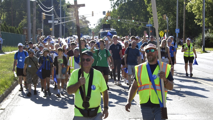 Participants of the 37th annual Piesza Polonija Pielgrzymka Maryjna (Polish Marian Walking Pilgrimage) approach Munster's Carmelite Shrine to eat, freshen up and later attend Mass celebrated by Bishop Robert J. McClory on Saturday night, Aug. 11. Overnight pilgrims, who walked from Chicago, then began the trek to Merrillville's Our Lady of Czestochowa Shrine in the morning, anticipating arrival for Sunday afternoon Mass. (Anthony D. Alonzo photo)