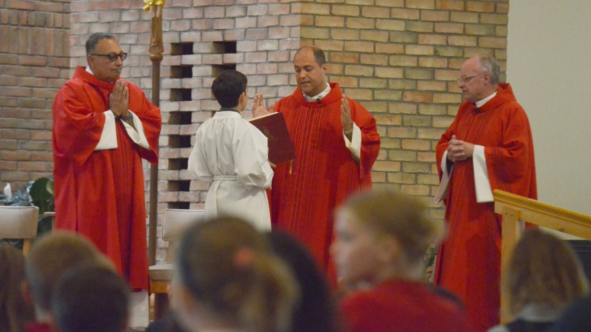 Father Don Paolo Ravaglia (center) presides over a Mass for St. Patrick Catholic School students on Aug. 14 with pastor Father Jon Plavcan (right) concelebrating and assisted by Deacon Gilbert Sanchez (left). Father Ravaglia, an Italian priest who serves on the Dicastery for the Causes of Saints for the Vatican, talked with the children during the homily about what it means to be a saint. (Erin Ciszczon photo)