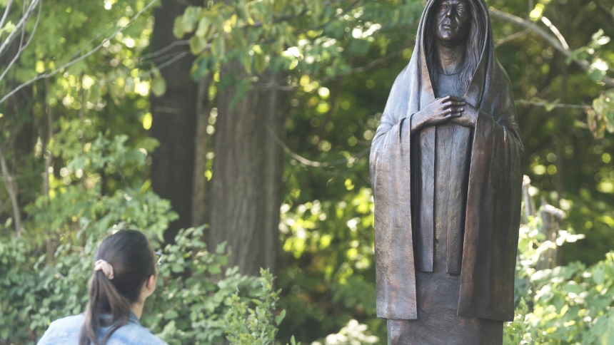 A visitor stands near a statue of Mary at Our Lady of Holy Cross Shrine at Holy Cross College in Notre Dame, Ind., after its dedication Sept. 4, 2024. (OSV News photo/Evan Cobb, courtesy Holy Cross College)