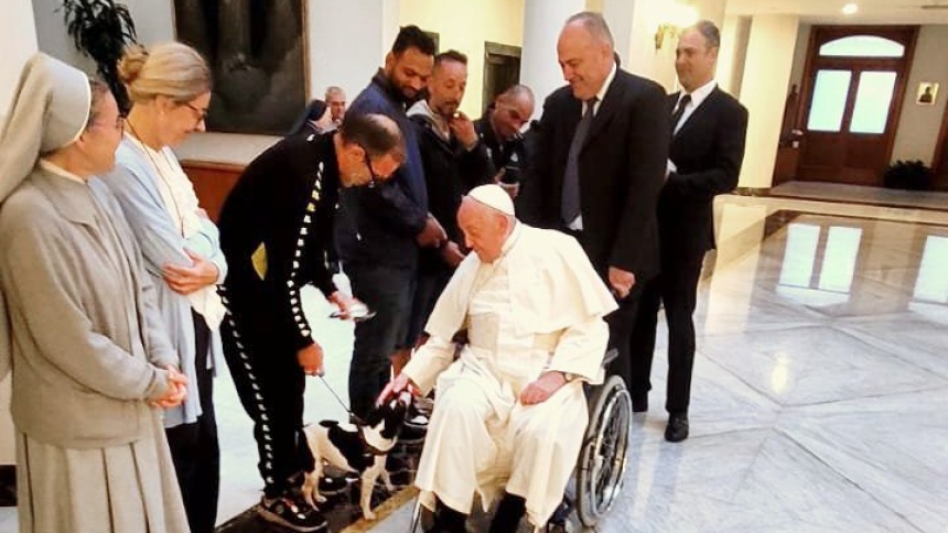 Pope Francis is greeted by a group of homeless people and religious Sept. 26, 2024, as he departs the Vatican for his apostolic trip to Luxembourg and Belgium. To a surprise of the pontiff, one of the homeless men had a dog with him, which made the pope laugh as he played with the animal. (OSV News photo/courtesy Dicastery for the Service of Charity) Editors: best quality available.