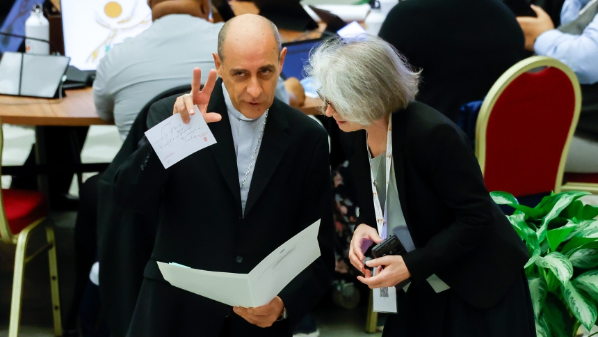 Cardinal Víctor Manuel Fernández, prefect of the Dicastery for the Doctrine of the Faith, speaks with Xavière Missionary Sister Nathalie Becquart, undersecretary of the Synod of Bishops, before the start of a morning session of the synod in the Paul VI Audience Hall at the Vatican Oct. 21, 2024. (CNS photo/Lola Gomez)