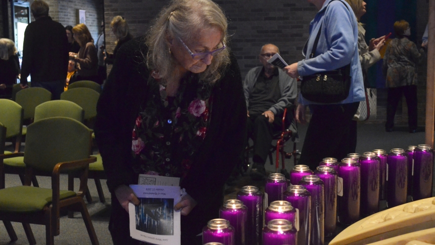 Kathy Emmett, of Crown Point, looks for the candle with her mother's name on it prior to the start of the Mass of Remembrance on Oct. 27 at St. Maria Goretti in Dyer.  Her mom, Patricia Ricciardi, passed away in January. (Erin Ciszczon photo)