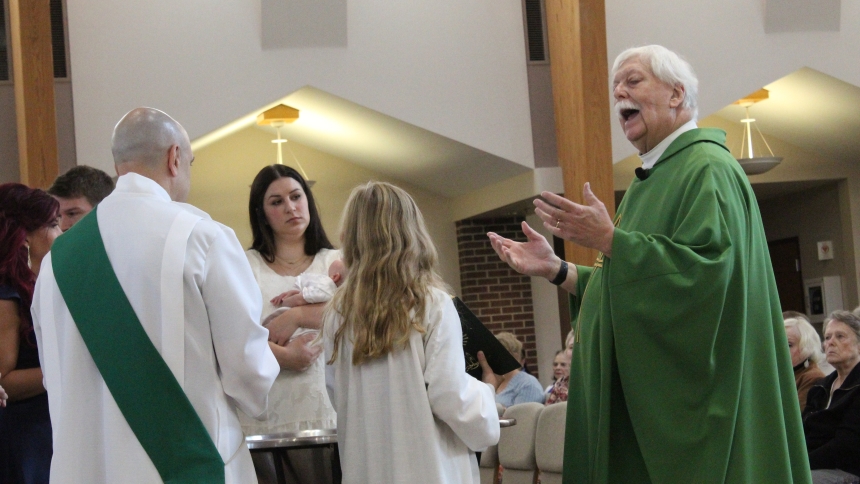 Father Thomas Mischler conducts a baptism during Mass on Sept. 29 at Holy Spirit in Winfield, where he has been pastor since July 1, 2010. He is now also pastor of St. Helen in Hebron and administrator of St. Mary in Kouts, creating One Catholic Family. (Marlene A. Zloza photo)