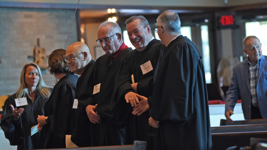 Active and retired Lake County judges exchange the Sign of Peace during the annual Red Mass at Our Lady of Consolation in Merrillville on Oct. 3. Legal professionals including attorneys and judges and financial experts including bankers gathered at the liturgy presided over by Bishop Robert J. McClory, which continues the Catholic tradition originating in the Middle Ages of invoking the guidance of the Holy Spirit for decision-makers. (Anthony D. Alonzo photo) 