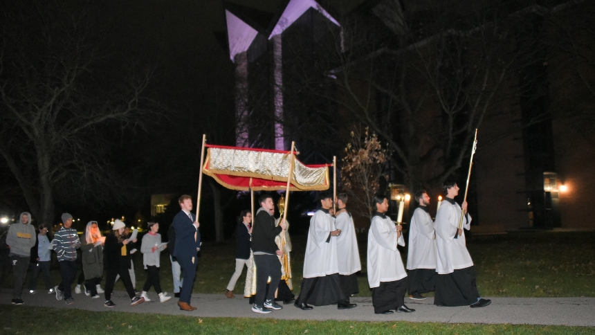 Members of St. Teresa of Avila Catholic Student Center led by Nathan Ringelstein (right) process with the Blessed Sacrament in a monstrance held by Father Jacob McDaniel, chaplain, near the Chapel of the Resurrection on the campus of Valparaiso University on the evening of Nov. 15. The Eucharistic Procession was coordinated as part of the Inspire program for collegians at the Valparaiso school, and, according to Father McDaniel, the first such prayer journey through the campus of the Lutheran-affiliated col