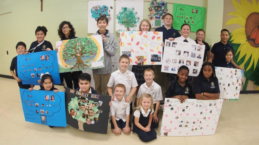 Queen of All Saints Catholic School students show off their family trees that were on display in the school’s cafeteria. Student pictured kneeling in the front row are Natalia Serrano, Matias Pacheco, Simon Arnold, Aaron Arnold, Adelaide Arnold, Christian Arnold, Ellianah Nabatanzi, and Prim Namakula. Back row includes Daniel Serrano, Jared Serrano, Eleanor Hopper, Gregory Hopper, Amelia Arnold, Dylan Nelson, Anna Nelson, Audrey Nelson, Jonathan Galindo, and Maelie Bowling. (Deacon Bob Wellinski photo)