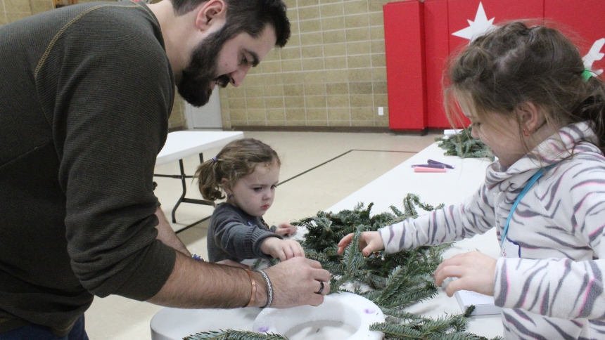 Nathan Finke helps his daughters, Delilah, 3, and Penelope, 6, create a family Advent Wreath at Nativity of Our Savior in Portage on Dec. 1. The trio attended Family Advent Day at their parish, where Penelope Finke said she likes Advent (and searching for Elf on the Shelf) because it leads to Christmas. (Marlene A. Zloza photo)