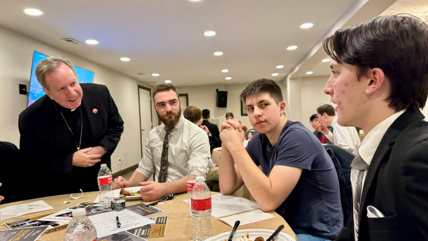 Bishop Robert J. McClory (left) greets discerners including Alexander Brown (right), 15, during the Andrew Dinner on Dec. 3 at St. John the Evangelist in St. John. The event, hosted by the diocesan vocations office team, is a causal gathering designed to support those who may have a calling to the priesthood and is based on the traditional view that Andrew the apostle was first to share the Good News, having located his brother Simon to bring him before Jesus. (Anthony D. Alonzo photo)