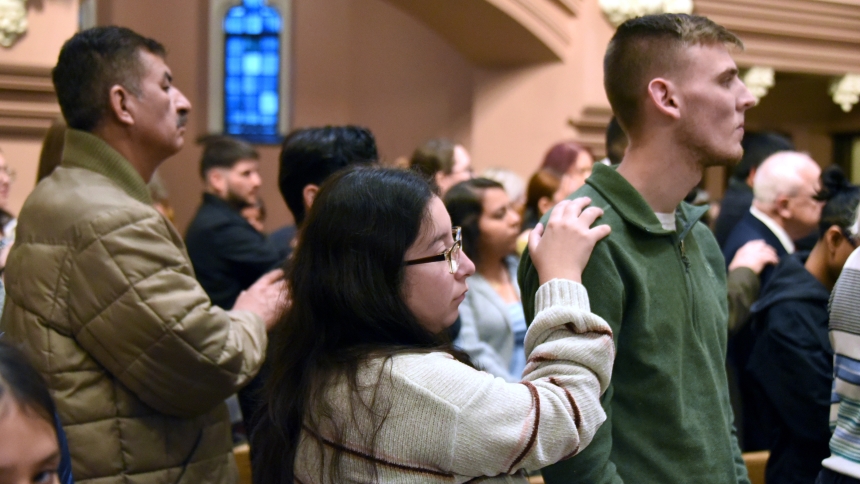Sponsor Angelina Andrade (front, center) places her hand on the shoulder of Christian candidate Jacob Rothchild (front, right), both of St. Mary of the Lake, at the Cathedral of the Holy Angels in Gary on Nov. 24. Seekers from throughout the diocese were presented at the liturgy to Bishop Robert J. McClory and will continue in their conversion with the assistance of the faithful, as they anticipate full communion with the Catholic Church. (Anthony D. Alonzo photo)