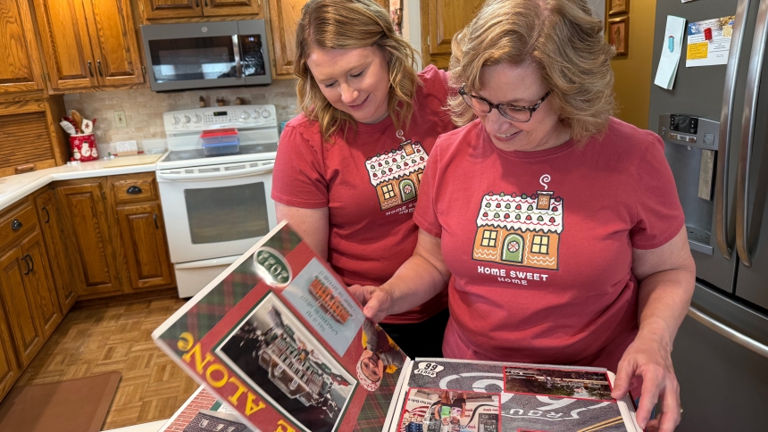 Sue Holzbauer and her daughter, Bailey Thompson, look through a scrapbook of gingerbread houses they have created in the past in this undated photo. When they heard that the new St. Mary's School was being built in Breckenridge, Minn., they decided that it would be their gingerbread "house" to build in 2024. (OSV News photo/Dianne Towalski, The Central Minnesota Catholic)