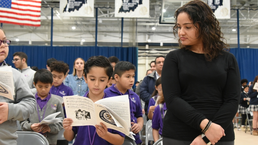 St. Casimir school of Hammond second-grade teacher Abigail DeJesus Hernandez (right) and one of her students Martin Mendoza Becerra (center) look at a program as they sing a hymn at a diocesan Catholic Schools Week Mass hosted at Bishop Noll Institute in Hammond on January 29. Presider Bishop Robert J. McClory encouraged students gathered from Our Lady of Grace, St. Casimir, St. John the Baptist, St. John Bosco and St. Stanislaus to be like the seeds that took root in the day's Gospel reading from Mark chap